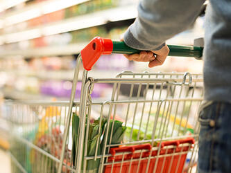 supermarket shopper pushing trolley with groceries